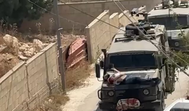 Siyonist işgalciler Filistinli bir genci,askeri araca bağlayıp canlı kalkan olarak kullandı